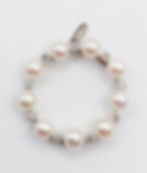 Bracelet perlé blanc, détails brillants, fermoir argenté, fond blanc, bijou élégant.