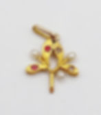Pendentif fleuri en or, perles et pierres précieuses, sur fond blanc.