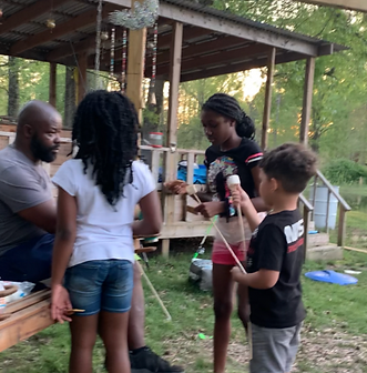 Family roasting marshmallows around a fire pit at Bigdog Farm.