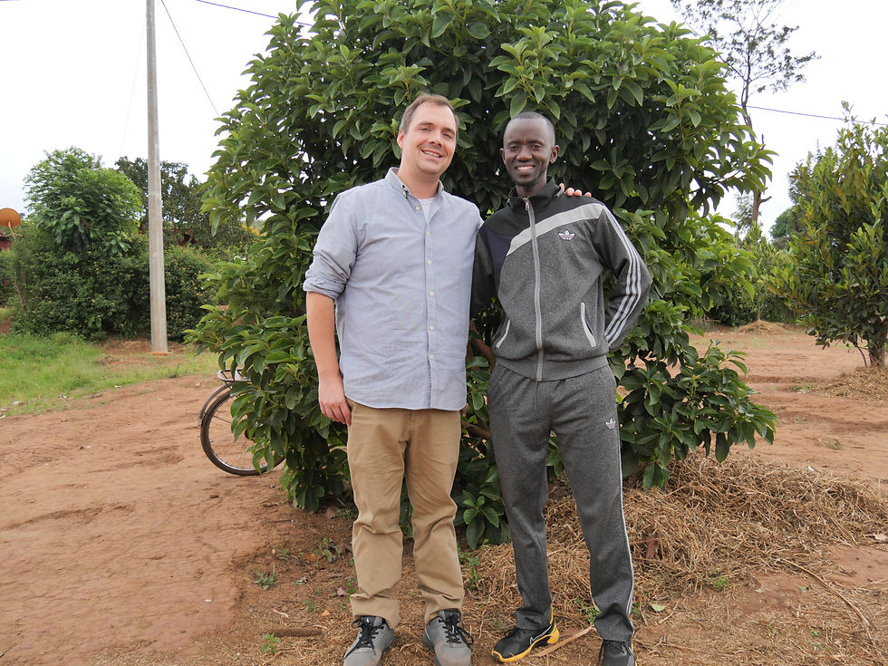 Jimmy Hummer (MCC Rep) and Gratien Nibigira (Director of Restobu) stand in front of an avocado tree planted by the Peace club members