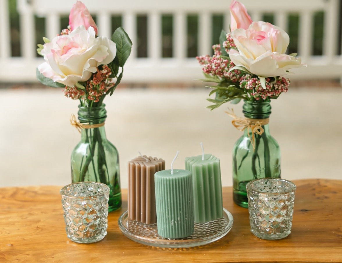 Circular candle in turquoise on decorative display.