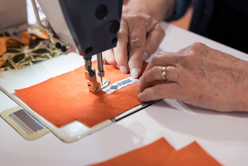 La créatrice au travail, gros plan sur l'aiguille de la machine à coudre et de l'expertise des mains