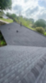 Aerial view of a newly installed charcoal gray architectural shingle roof on a residential home.