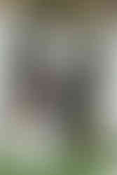 Bride and groom exchanging vows during ceremony with officiant holding an umbrella over them