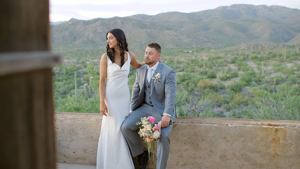 Couple posing for couple's portraits surrounded by cacti as taken by an Arizona wedding videographer