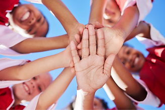 Kids hands huddle.png