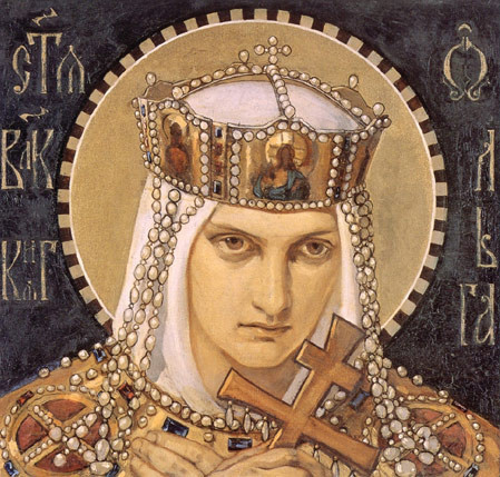 A young woman with a head covering, crown and with a halo behind her head looks menacing while holding a cross.