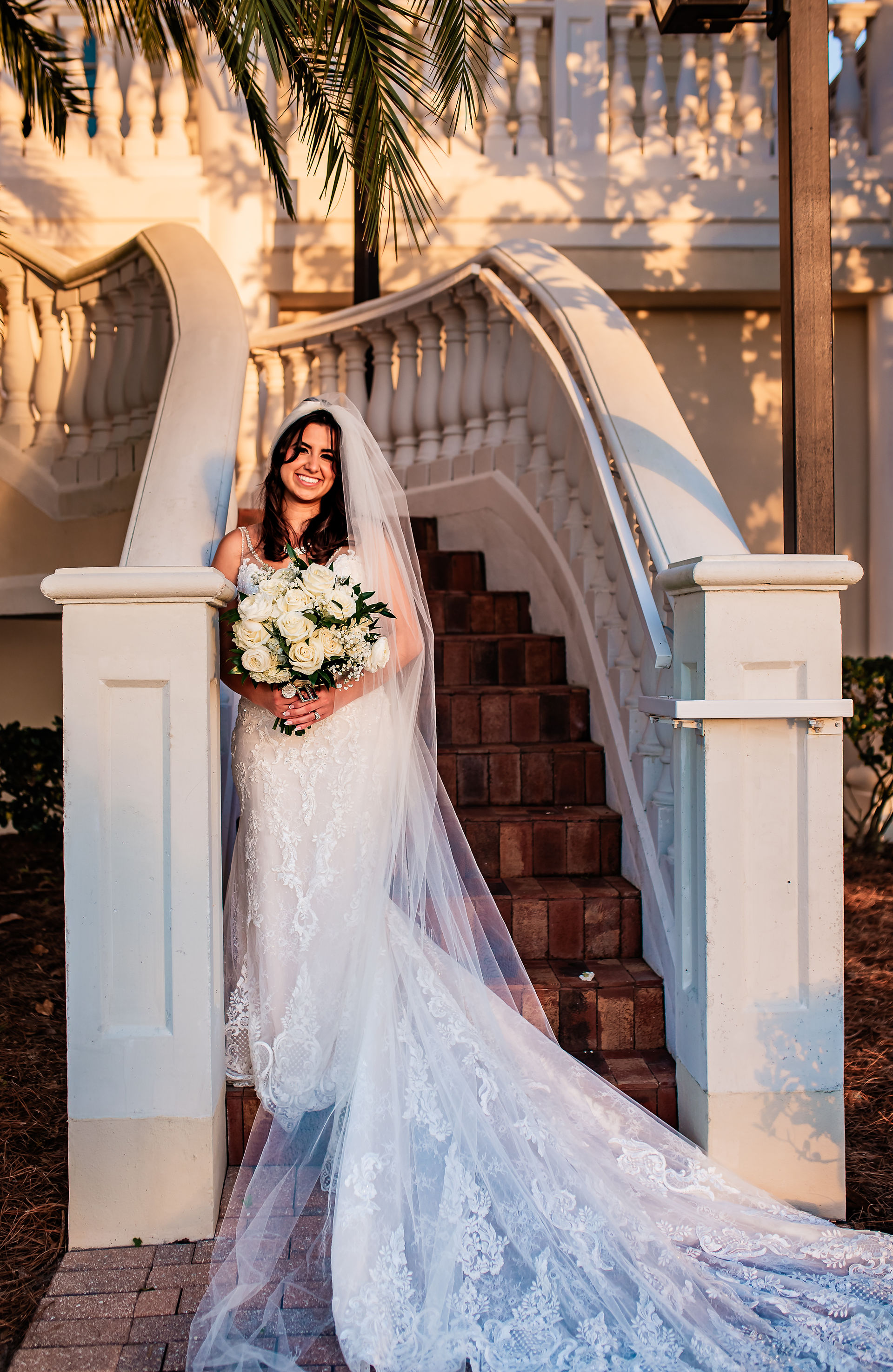 Bride standing on stairs looking into sunset