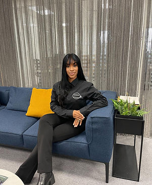 Ebony Schrils, Operations Manager of Yeril Ltd, seated on a navy sofa in the office.