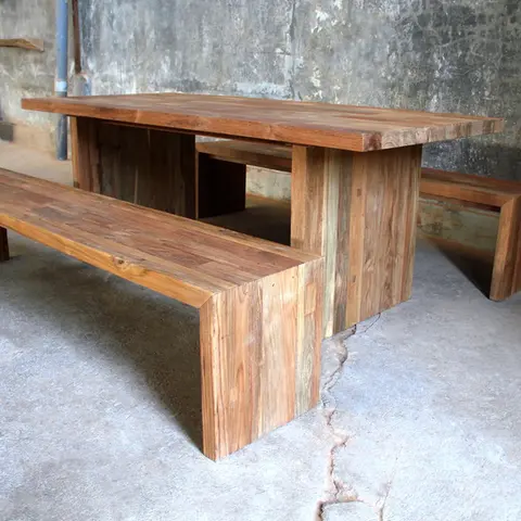 Side view of rustic teak outdoor dining table with matching solid wood bench, perfect for garden or patio settings.
