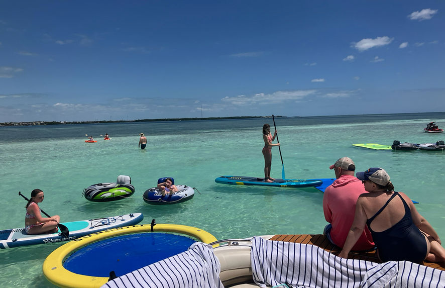 People paddleboarding and relaxing in turquoise water.