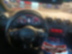 Interior de Audi con tablero, volante y logo Carskeygaby.