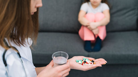 female-doctor-holding-glass-water-medicines-hand-standing-front-sick-girl-sitting-sofa.jpg