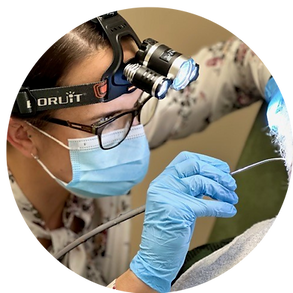 Image of WNDA audiologist undertaking ear wax removal process on a patient, using water pulse irrigation technique