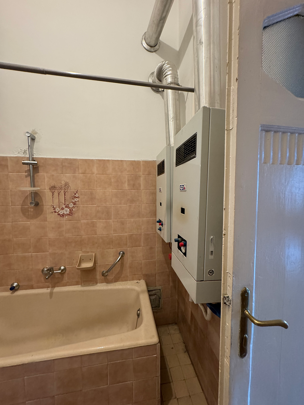 Original bathtub and wall-mounted boiler — before renovation, Hadik Ház, Budapest