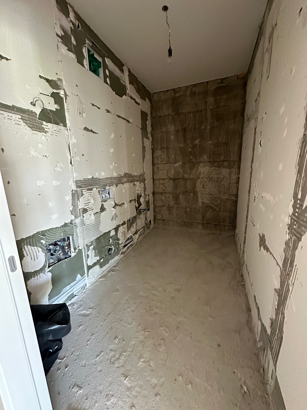 Stripped kitchen walls and exposed pipework during demolition, Ljubljana apartment