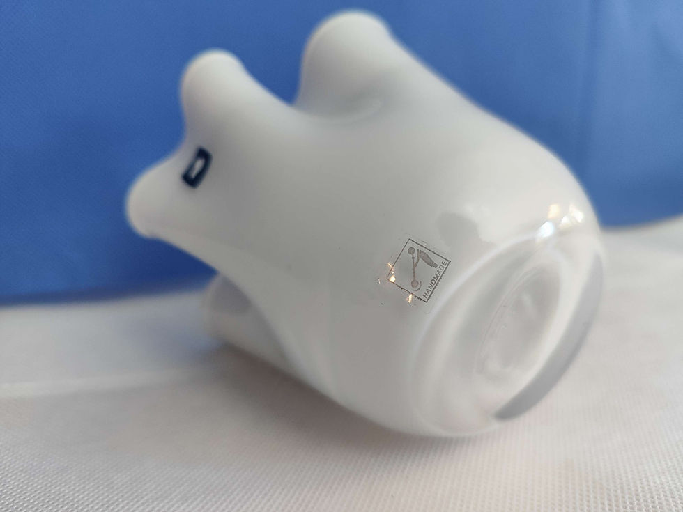 Thumbnail: base of a vintage hand blown handkerchief vase with a cloud shaped sticker on it with a white surface and blue background