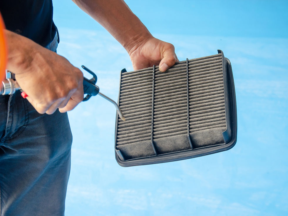 A man cleaning Car Air Filter with compressed air