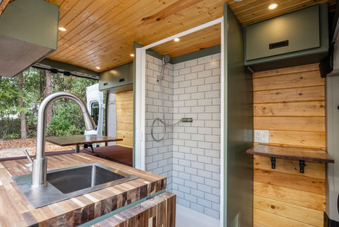 Van life camper van conversion with rustic hardwood finishes and shower