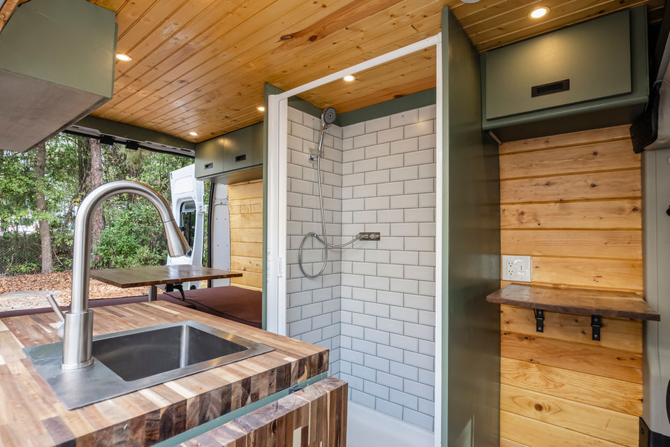 Van life camper van conversion with rustic hardwood finishes and shower