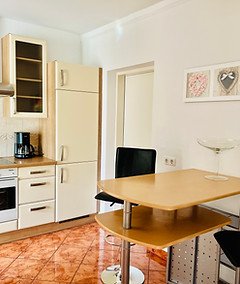 vollausgestattete Küche mit Tisch und Barhockern im Apartment Rauchkofel