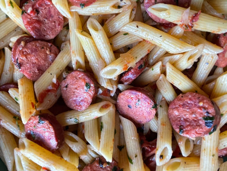 Close up photo of the Amaral's Linguica Pasta Dish. It is mainly composed of penne pasta and sliced sausage.