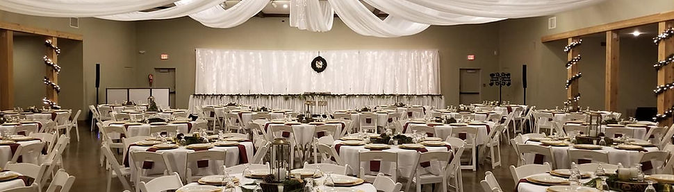 Main venue hall setup for wedding reception with tables, chairs, and dinnerware