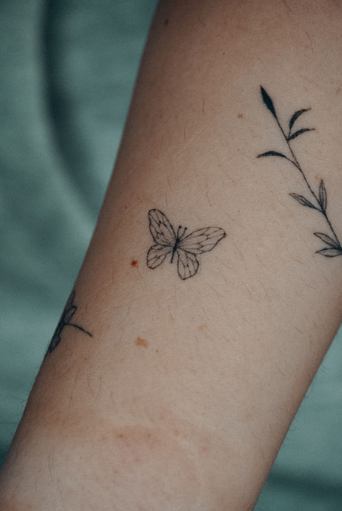 Fineline tattoo van een vlinder op de onderarm, gezet door Finelinetattoo Daniëlle in Vorselaar