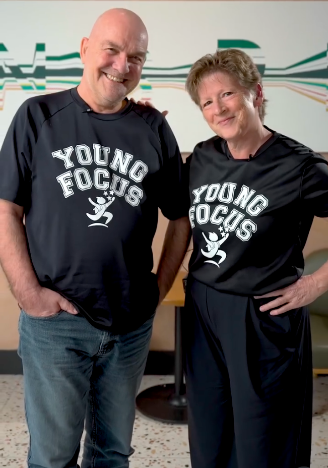 Ann van Wijgerden and Paul van Wijgerden standing together wearing matching black Young Focus shirts.