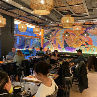 Filipino restaurant Soho London Kasa and Kin interior with diners enjoying modern Filipino cuisine under mural artwork