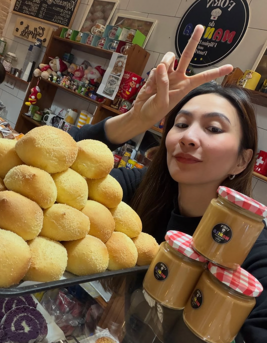 Rachelle Anne Daquis at Forn de Manila with a tray of freshly baked pandesal beside jars of peanut butter.