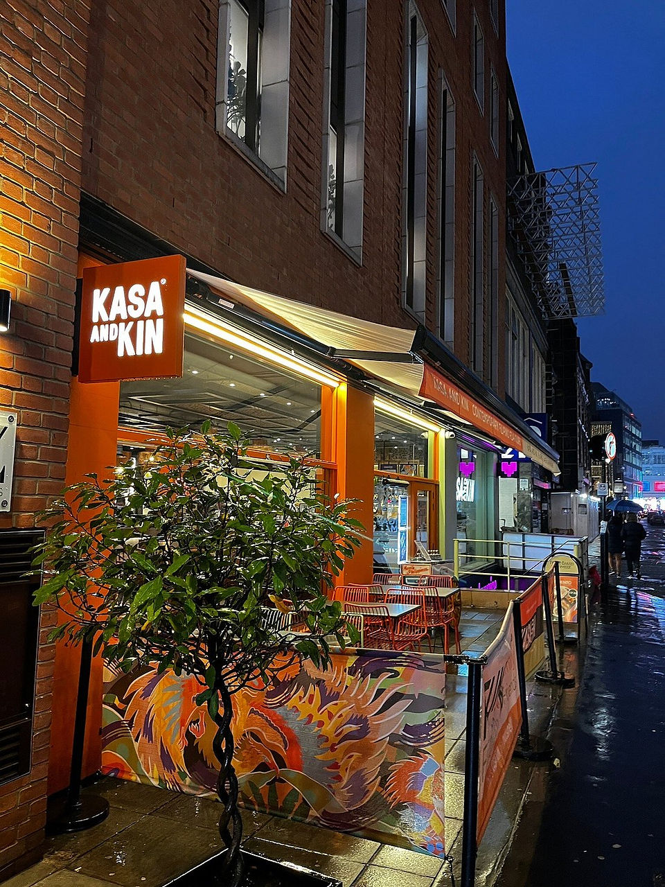 Kasa and Kin Filipino restaurant Soho London exterior on Poland Street at night with illuminated signage