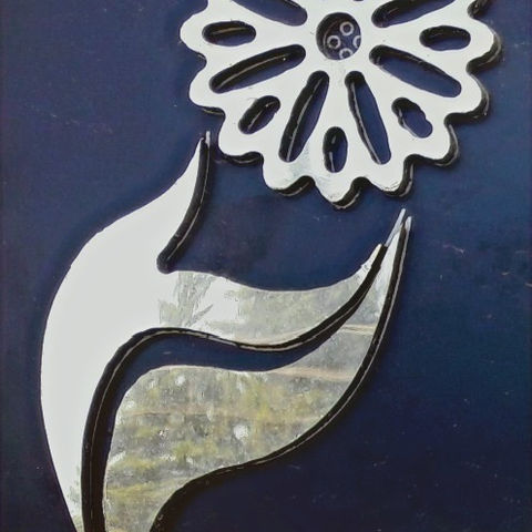 Koyu mavi zeminde gümüş renkli el çiçeği logosu detayı