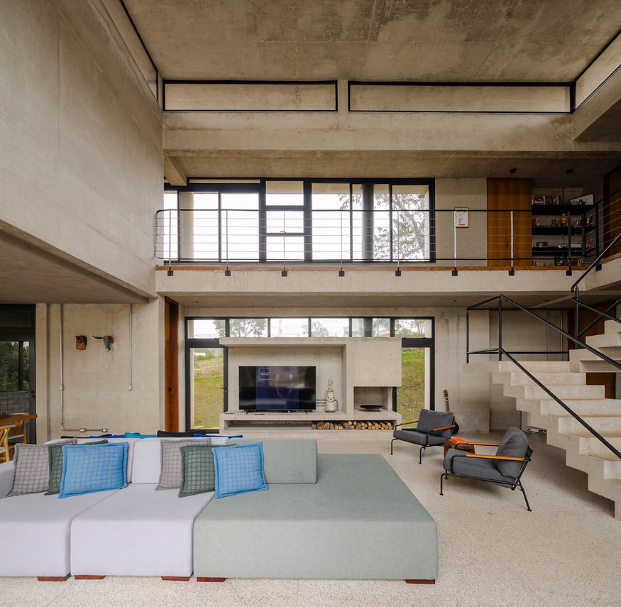 Sala de estar da Casa Eco com concreto aparente, madeira e grandes planos de vidro