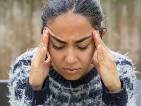 Woman with a headache, holding her head