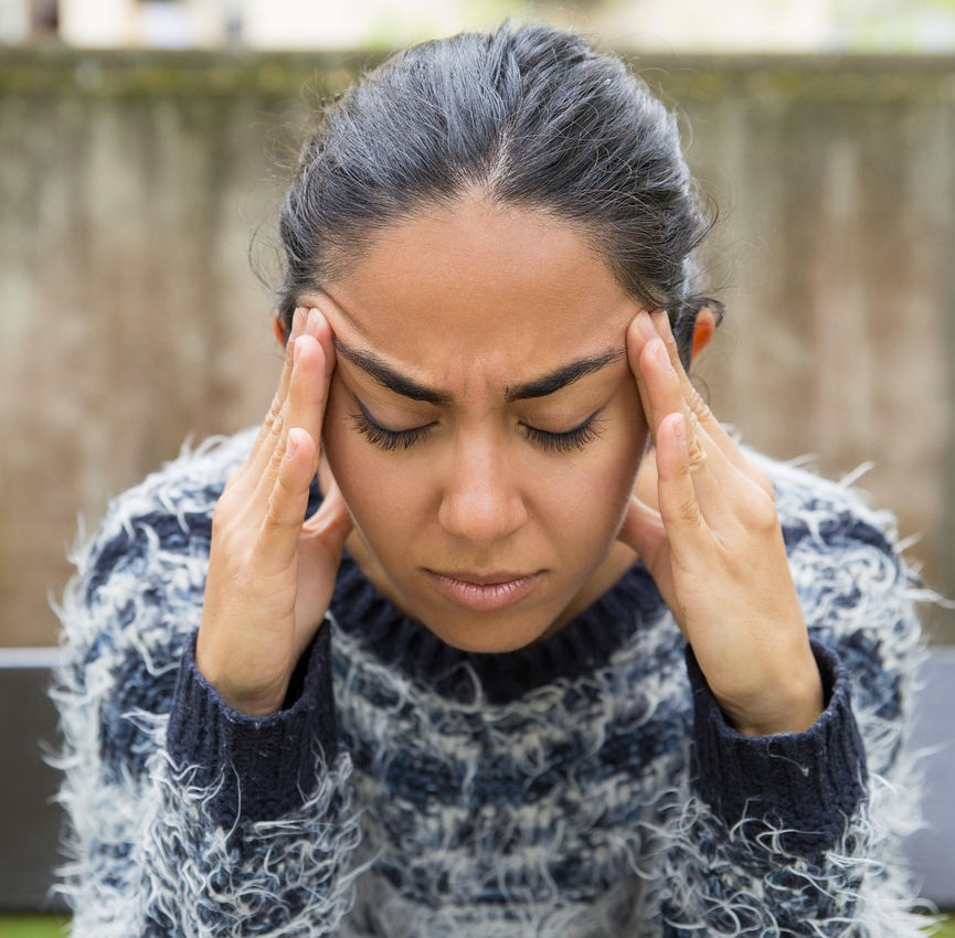 Woman with a headache, holding her head