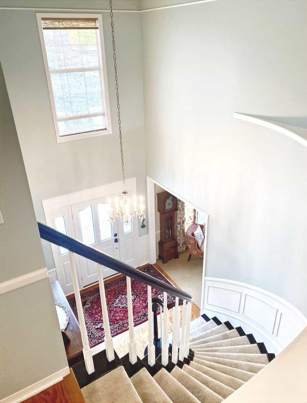 View looking down from upstairs landing with painted stairwell and stained railing
