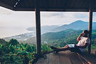 Hipster gut traveler working remote while enjoying Thailand nature landscape during summer