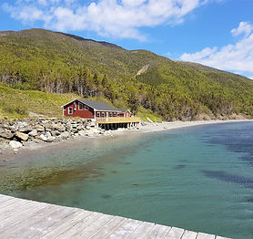 A red oceanside cottage nestled against the Blow Me Down Mountains in York Harbour, Newfoundland.