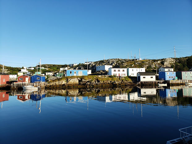 Houses and fishing stages on the rocky coastline in Southwestern Newfoundland.