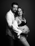 Partner grli trudnicu na jednostavnoj studijskoj pozadini