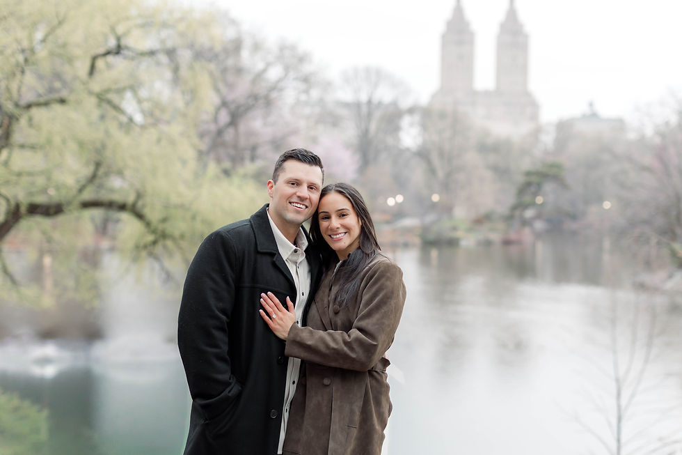Couple walking through Central Park after proposal with cherry blossoms in bloom