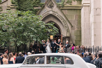 Bride and groom exiting the Church of St. Thomas More before their Central Park Boathouse wedding reception in New York City.
