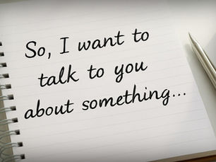 Handwritten note on a lined notebook page reading “So, I want to talk to you about something…” with a pen resting beside the notebook, suggesting reflection or letter-writing.