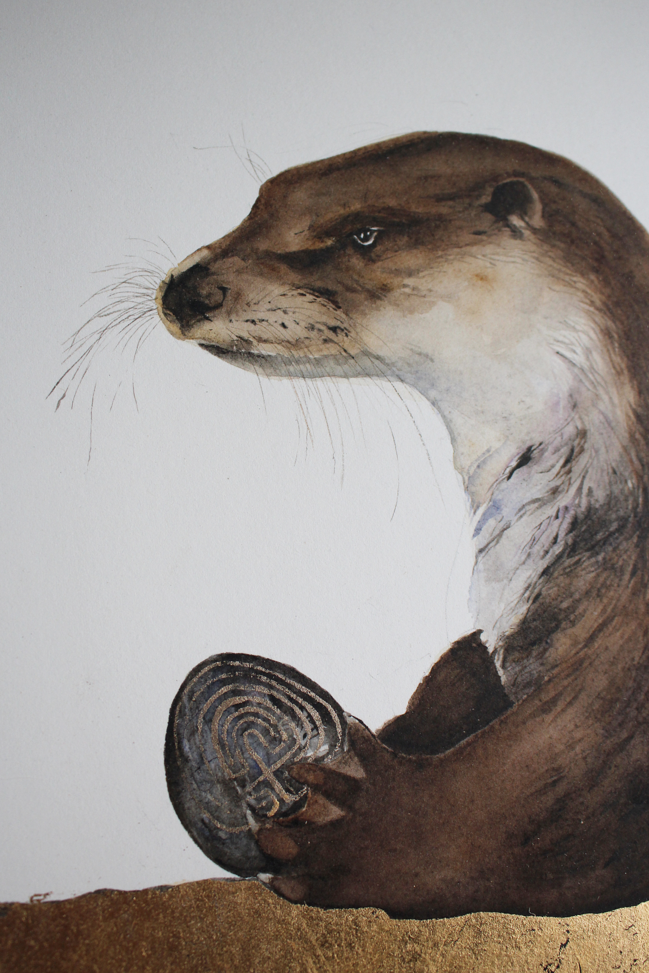 otter with labyrinth stone