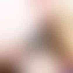 A blonde girl wearing a pair of black haunted house dangle earrings with orange accent window details. These earrings are from the Cat Creations Halloween 2024 Collection.