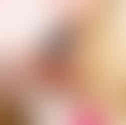 Blonde girl wearing a pair of dangle earrings featuring a cute black cat peering out of the top of an orange carved pumpkin. These earrings are from the Cat Creations Halloween 2024 Collection.