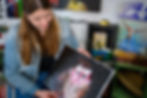 Thumbnail: a woman with brunette hair looks down at a painting of an owl