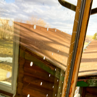 a series of white stickers that appear like dots are in a grid on a window surface.
