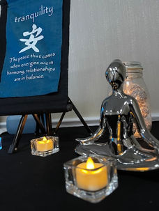 Serenity Sounds mascot, peaceful lotus girl, bathed in candle light next to banner for tranquility.